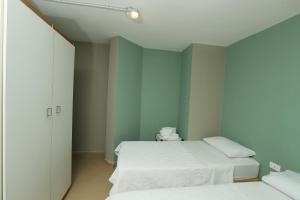 two beds in a room with green walls at Cimer SafraMarine Beach Resort in Safra
