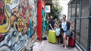 a group of people with luggage standing next to a wall at Merge Hostel in Bangkok