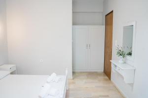 a white room with a bed and a mirror at Afroditi Pansion in Agios Nikitas