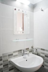 a bathroom with a white sink and a mirror at Afroditi Pansion in Agios Nikitas