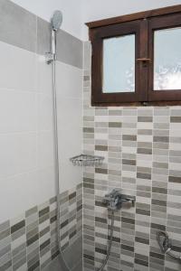 a bathroom with a shower with a glass door at Afroditi Pansion in Agios Nikitas