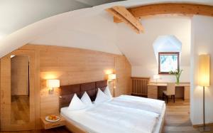 a bedroom with a large white bed in a attic at Hotel Fil Da Mont in Selva di Val Gardena