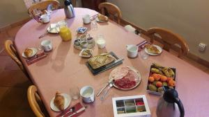 a pink table with breakfast foods on it at Les Rives de l'Andelle in Romilly-sur-Andelle +23 photos
