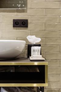 - un comptoir avec un lavabo et un bol dans l'établissement C-Hotels Continental, à La Panne