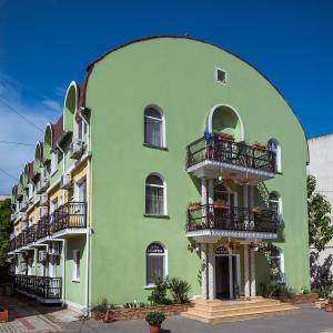 a green building with balconies on the side of it at COMPLEX Alutus -Camere de inchiriat in Mangalia