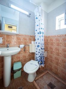 a bathroom with a toilet and a sink at COMPLEX Alutus -Camere de inchiriat in Mangalia