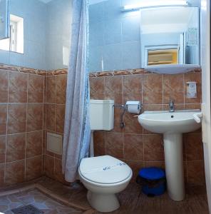 a bathroom with a toilet and a sink at COMPLEX Alutus -Camere de inchiriat in Mangalia +49 photos