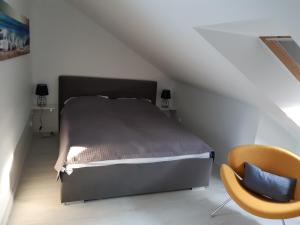 a bedroom with a bed and a yellow chair at Apartamenty Platinum 2 in Łukęcin +23 photos