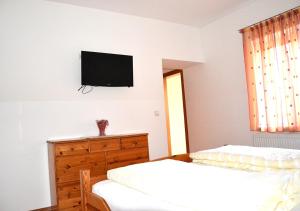 a bedroom with two beds and a television on the wall at Gasthof zum Goldenen Pflug in Amstetten