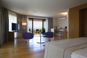 a hotel room with a bed and two chairs and a television at ON'LIVE HOTEL in Çeşme
