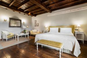 1 Schlafzimmer mit einem großen Bett und 2 Stühlen in der Unterkunft Áurea Palacio de Sober by Eurostars Hotel Company in Sober