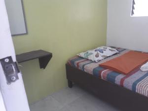 a small bedroom with a bed and a night stand at Dahilig Resort in Puerto Galera