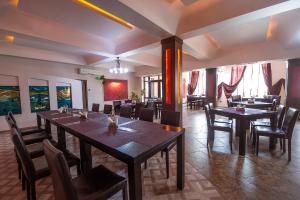 a restaurant with tables and chairs in a room at COMPLEX Alutus -Camere de inchiriat in Mangalia
