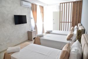 a hotel room with two beds and a flat screen tv at Helada Apartments in Tivat