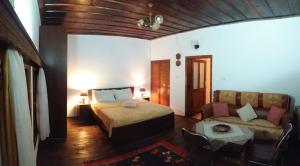 a bedroom with a bed and a couch at Guest House Mikel in Berat