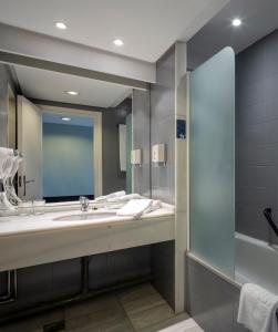 La salle de bains est pourvue d'un lavabo et d'un miroir. dans l'établissement Hotel Ciudad de Logroño, à Logroño