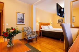 a hotel room with a bed and a chair and a table at Best Western Hotel Esplanade in Västerås