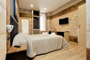 Un dormitorio con una cama y un televisor en una pared. en Gialli Vatican Guesthouse, en Roma