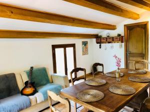 - un salon avec une table en bois et une guitare dans l'établissement Maison de caractère Toudon - Arrière Pays Niçois - Proche Nice, à Toudon