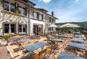 a patio with tables and chairs and a building at Logis Hôtel la Vigotte in Girmont-Val-dʼAjol