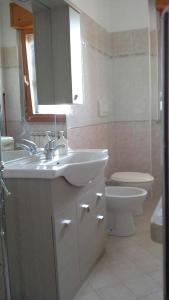 a bathroom with two sinks and a toilet and a mirror at Spazio e tranquillità a Roma in Rome