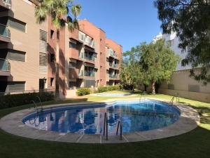 - une piscine en face d'un immeuble dans l'établissement APARTAMENTO 2ª LINEA DE PLAYA, à Roquetas de Mar