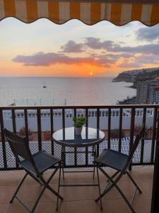 a table and chairs on a balcony with a view of the ocean at Casa Hana in Mogán