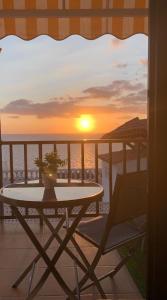 a table and a chair on a balcony with a sunset at Casa Hana in Mogán