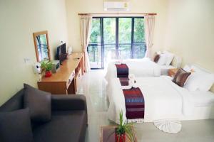 - un salon avec un lit blanc et un canapé dans l'établissement ChiangRai Lake Hill, à Chiang Rai