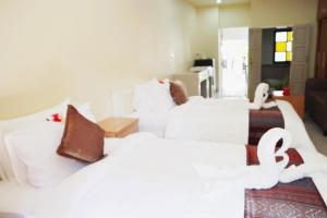 ein Hotelzimmer mit 2 Betten mit weißer Bettwäsche in der Unterkunft ChiangRai Lake Hill in Chiang Rai