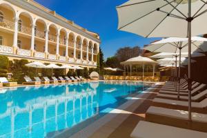 a swimming pool with chairs and umbrellas next to a building at Palace Del Mar in Odesa