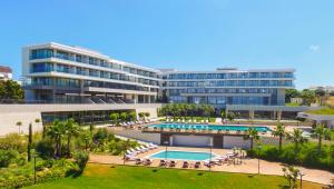 an external view of a large building with a swimming pool at ON'LIVE HOTEL in Cesme