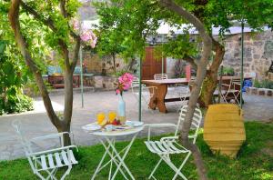 a table and chairs in a yard with a table and drinks at Aria di Rodi in Rhodes Town