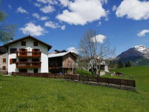 a house on top of a hill with a fence at Rocca B&B in Rocca Pietore