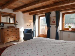a bedroom with a bed and a chair and a window at Rocca B&B in Rocca Pietore