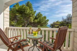 een patio met 2 stoelen en een tafel op een balkon bij Apartments Gilve in Hvar