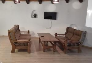 ein Wohnzimmer mit zwei Stühlen, einem Tisch und einem Fernseher in der Unterkunft Bluegreen Studios in Pefkari