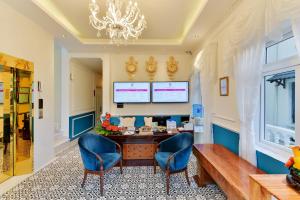 a room with a desk and two blue chairs at Dalat Boutique Hotel in Da Lat