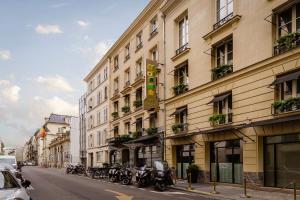 巴黎的住宿－米尼斯特爾酒店，停在建筑物一侧的一排摩托车