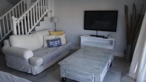 a living room with a couch and a tv at Waterside Living CAN05 in Jeffreys Bay