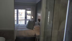 Un dormitorio con una cama y una puerta de cristal. en Waterside Living CAN05, en Jeffreys Bay