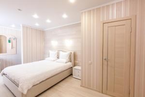 トムスクにあるSlobodaのベッドルーム1室(白いベッド1台、ドア付)