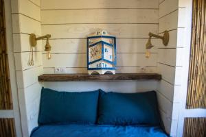 a blue bed with a clock on a wall at Les Maisons de pêcheurs in Sète