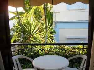 - Balcón con mesa blanca y sillas en Jasmine's Guest House, en Karlovasi