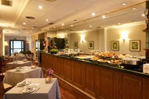 a buffet line in a restaurant with tables and food at Suites Barrio de Salamanca in Madrid