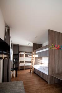 a bedroom with bunk beds with a desk and a table at L-Appartements in Burgau