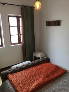 
a room with a bed, a lamp, and a window at Guest House D'Avenida in Vila Praia de Âncora
