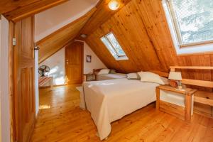 a bedroom with a large bed in a attic at Beautiful cottage with heated pool for 22 ppl in Plaški