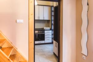 una cocina con armarios blancos y una escalera en East Station Private Rooms & Apartments, en Budapest