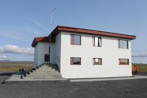 a white building with stairs leading up to it at Holssel road 864 in Myvatn